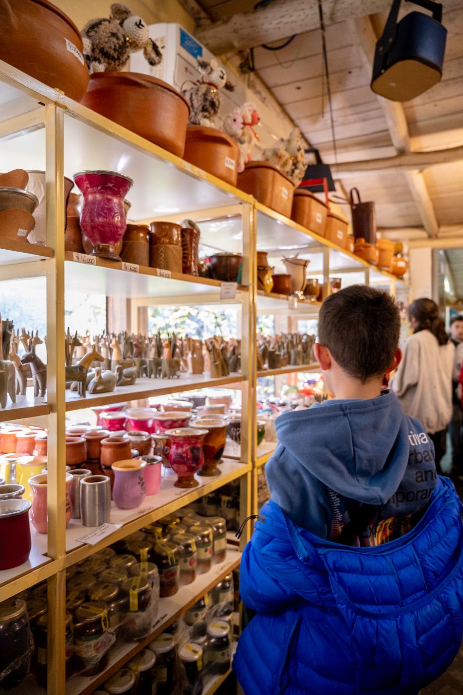 Estanterías con mates de cerámica, cuero y algarrobo, artesanías y dulces en el local de El Cazador