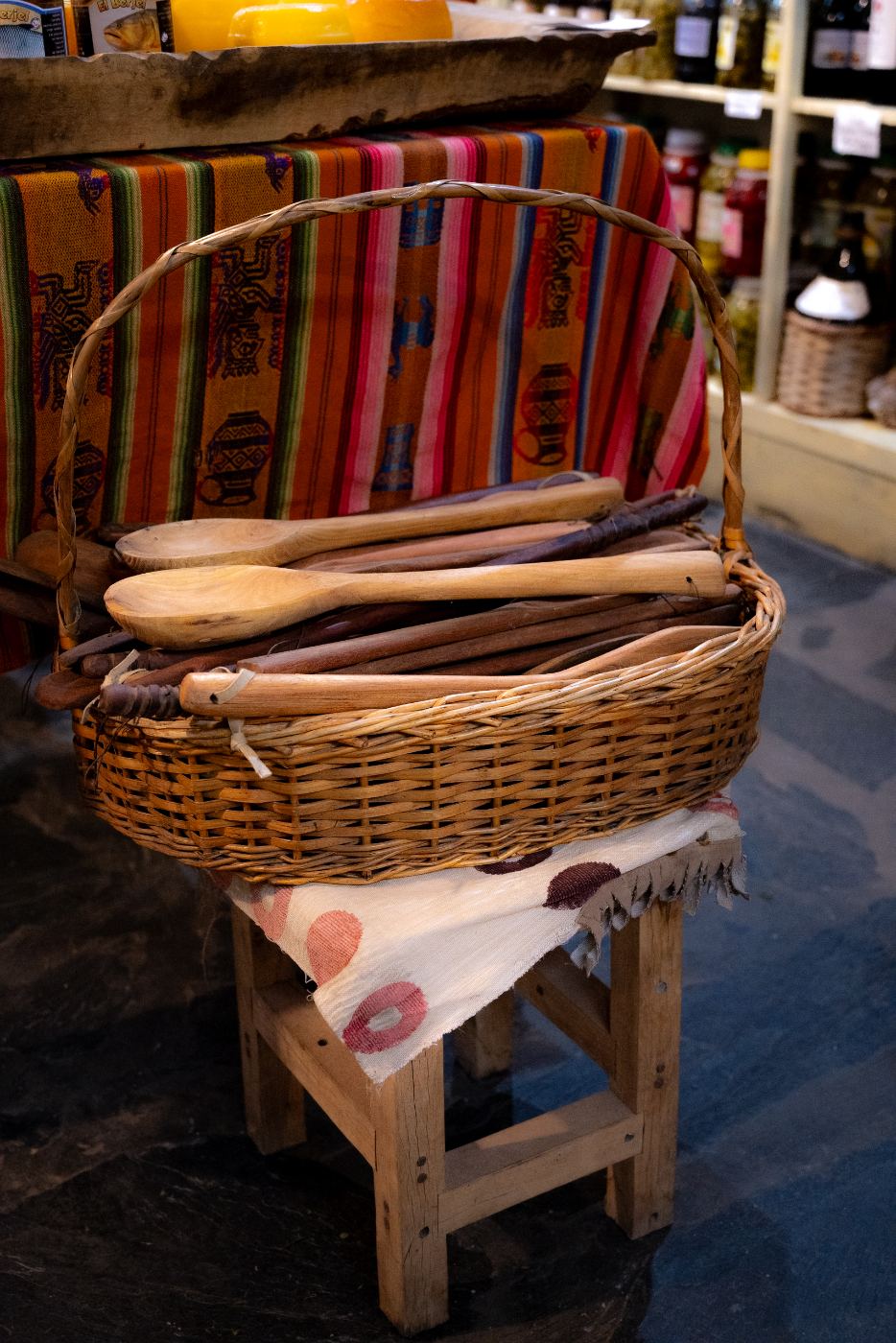Canasto de mimbre con cucharas y espátulas de madera artesanales en el local de El Cazador, Tandil